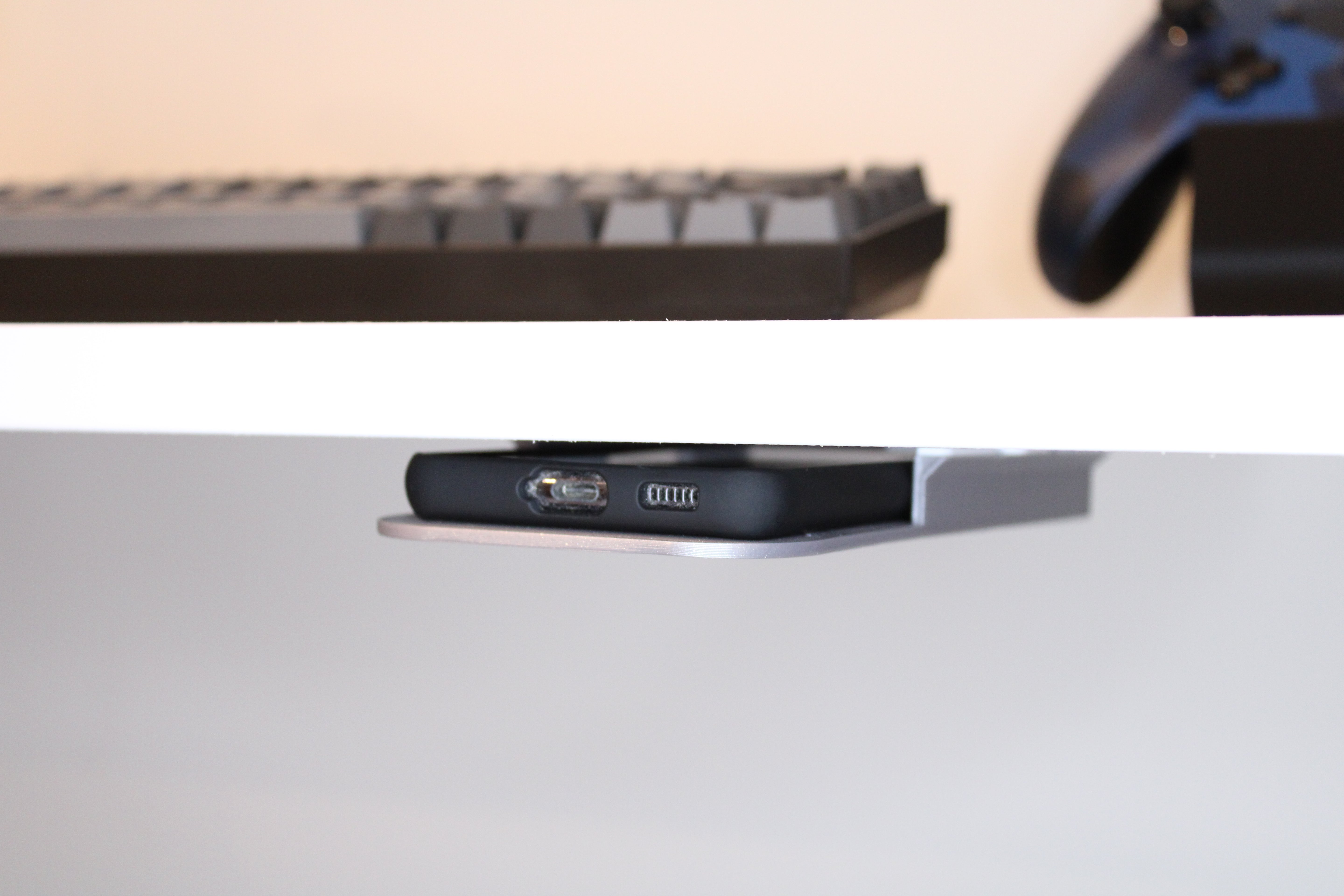 Phone holder for the underside of the desk