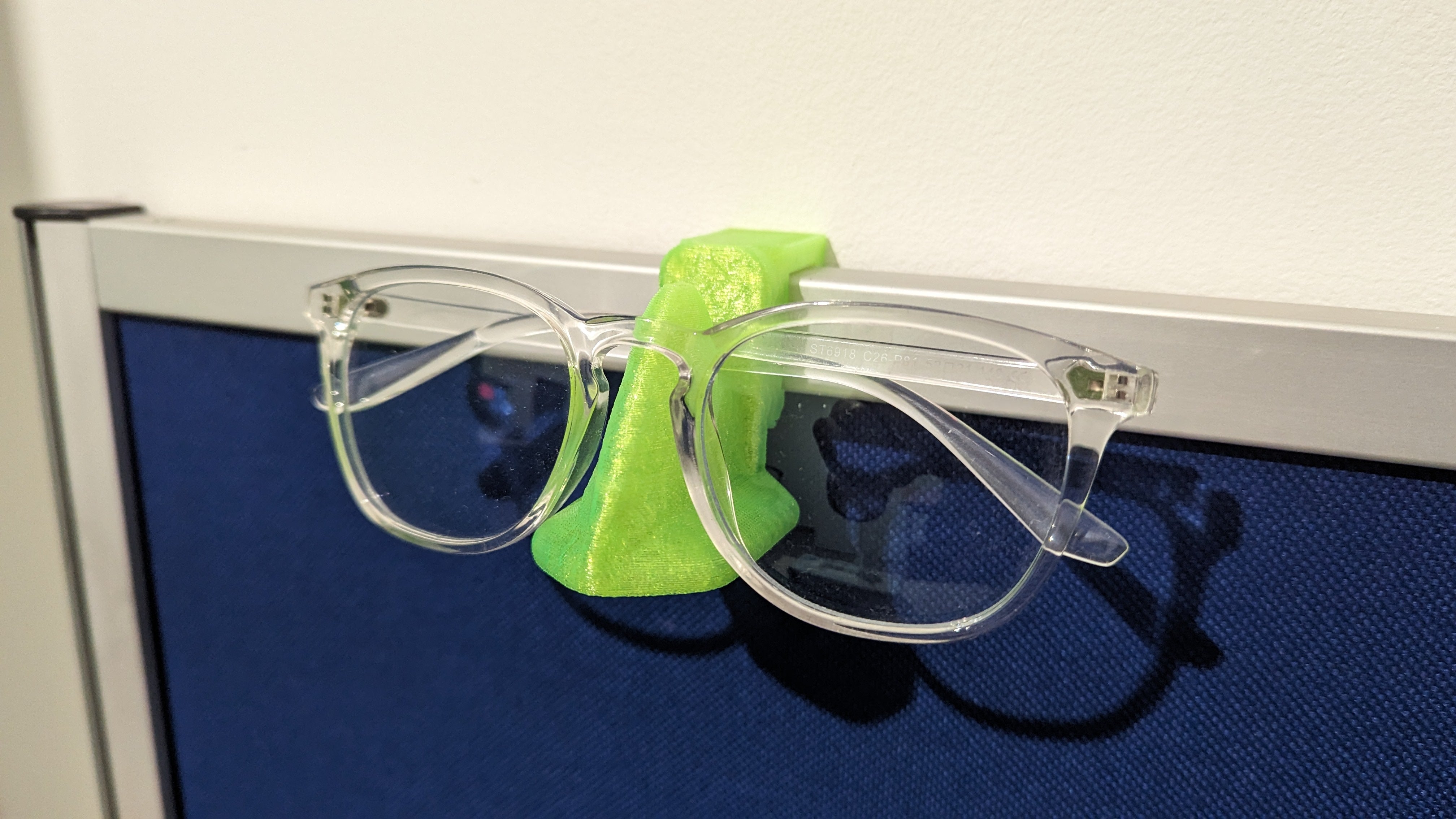 Nose-shaped glasses holder for desk screen