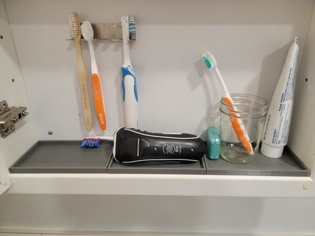 Toothbrush holder for medicine cabinet