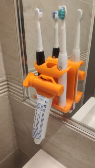 Wall holder and toothpaste squeezer for toothbrush